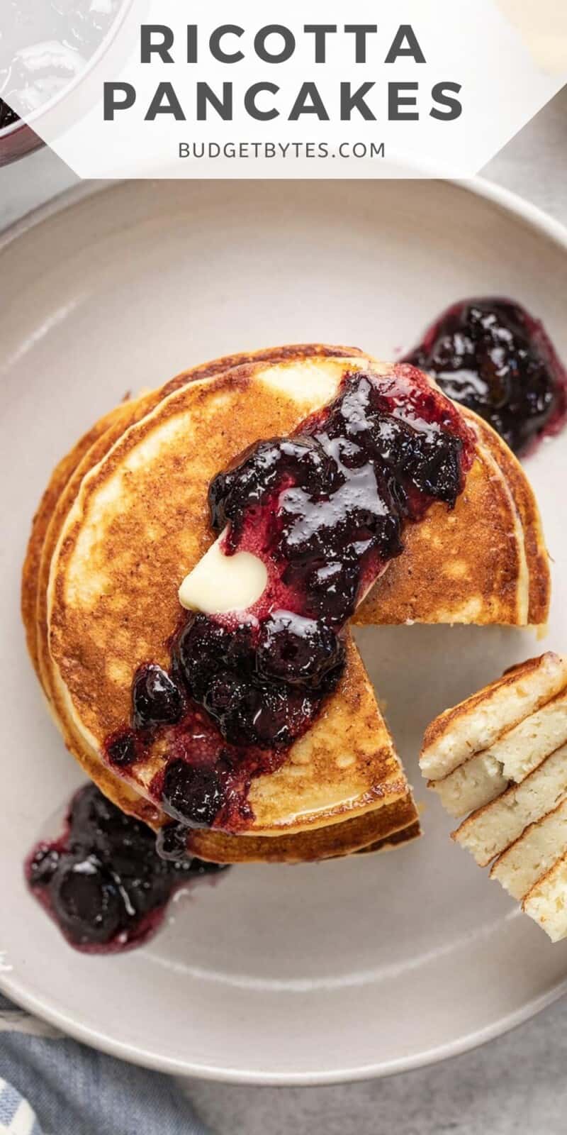 Overhead shot of ricotta pancake stack with blueberry sauce and a fork with a slice of the stack on it.