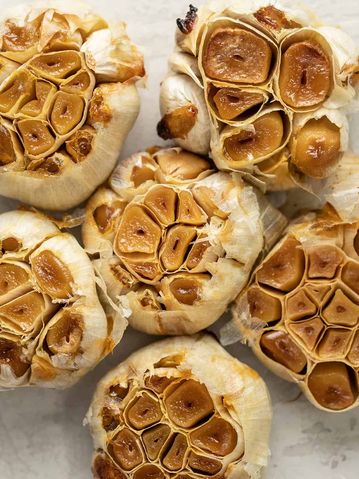 close up overhead view of several heads of roasted garlic.