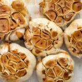 Close up overhead view of bulbs of roasted garlic.