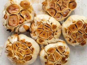 Close up overhead view of bulbs of roasted garlic.