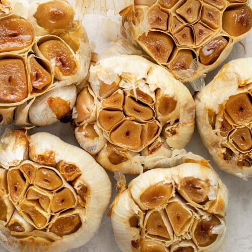 Close up overhead view of bulbs of roasted garlic.