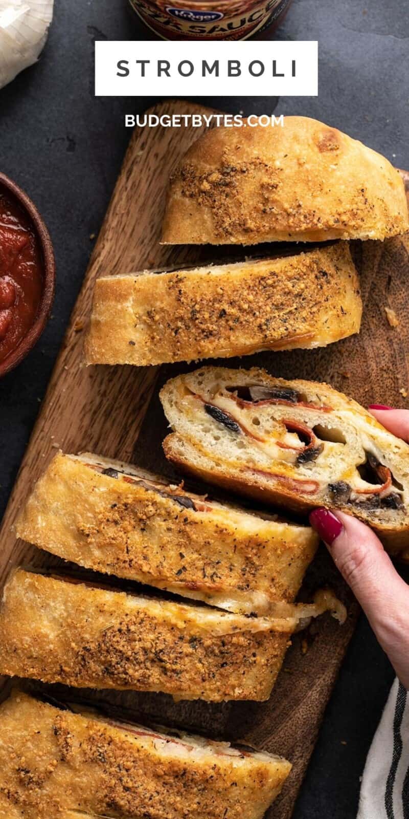 Overhead view of a hand taking a slice of stromboli.