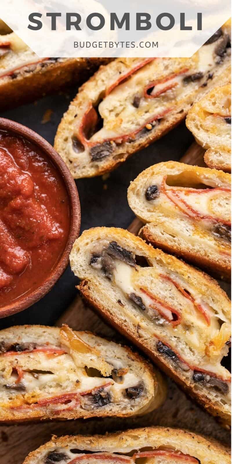Overhead view of stromboli slices near a bowl of pizza sauces.