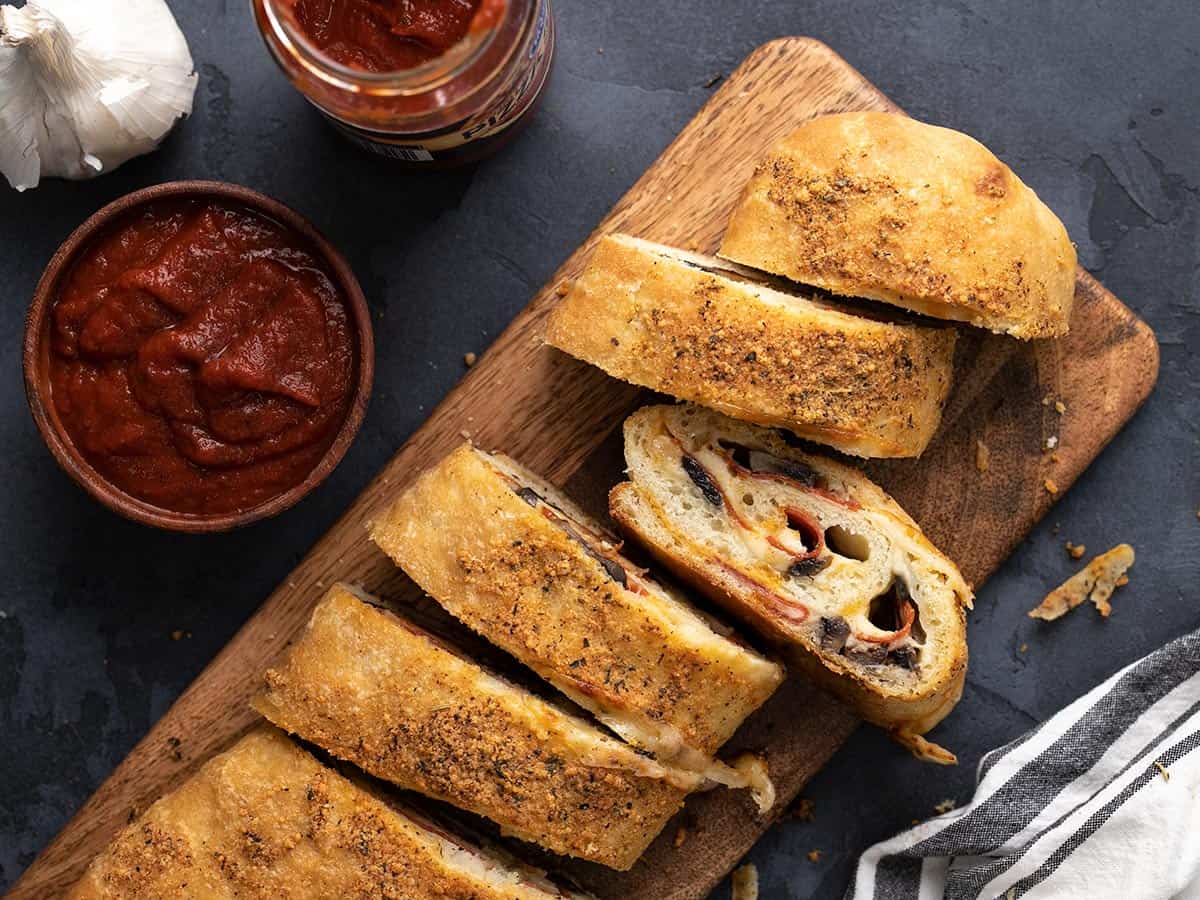 Sliced stromboli on a wooden cutting board, viewed from above.