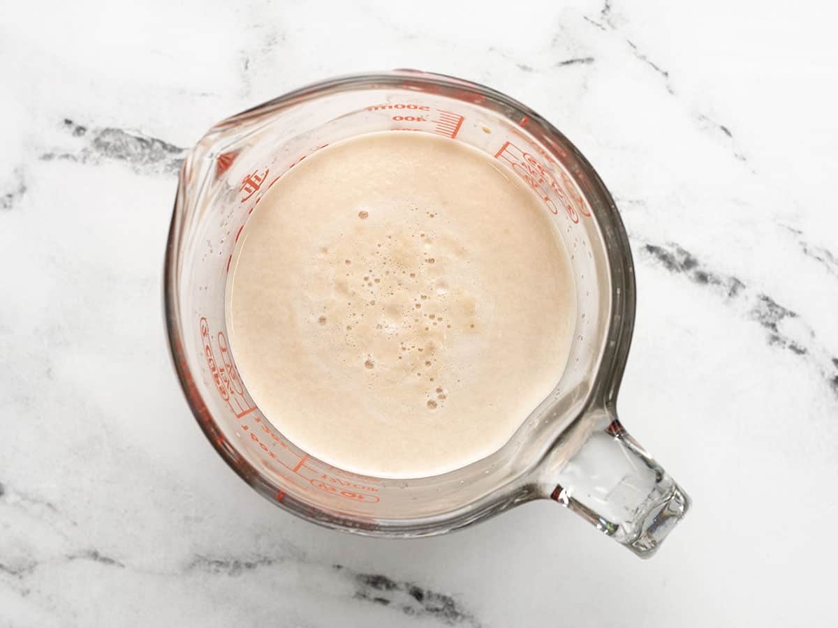 Proofed yeast in a glass measuring cup.