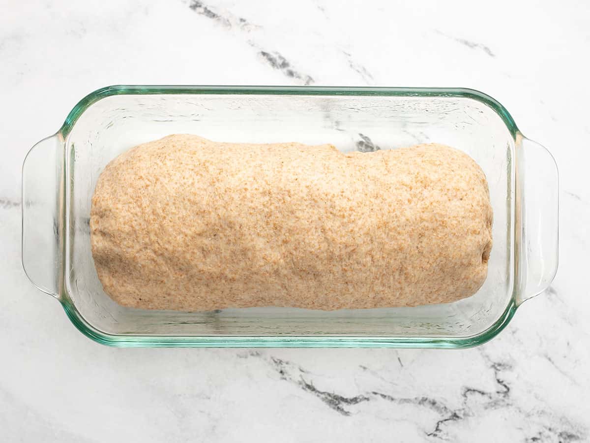 Dough in a glass bread pan.