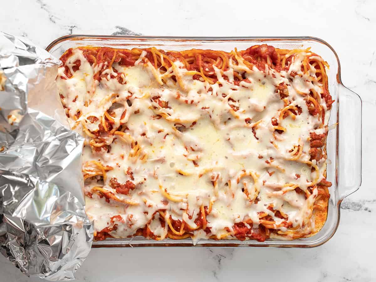 Baked spaghetti with foil being removed.