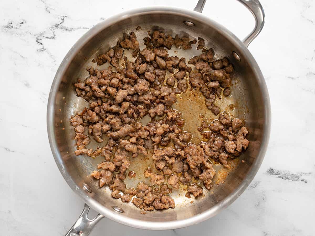 Browned Italian Sausage in the skillet.