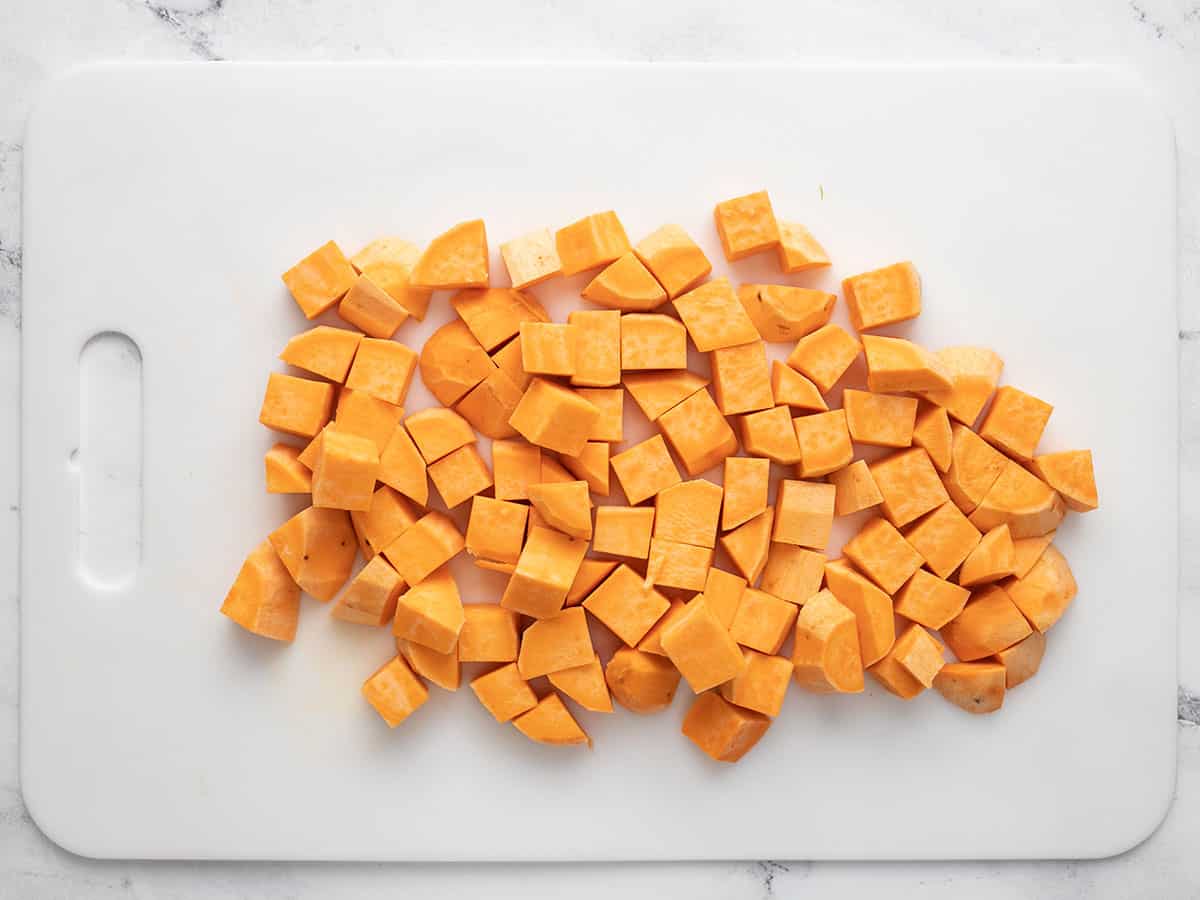 Diced sweet potatoes on a cutting board.