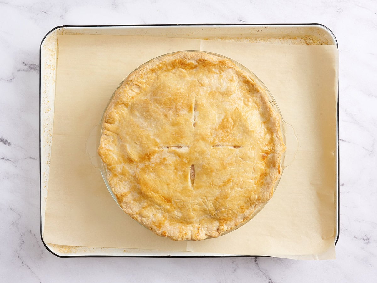 A finished apple pie on a baking sheet.