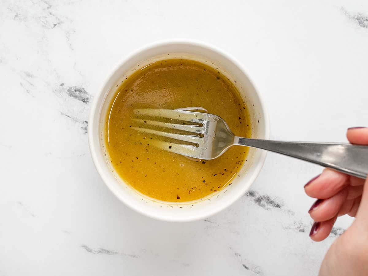 Maple Dijon vinaigrette in a small bowl with a fork. 