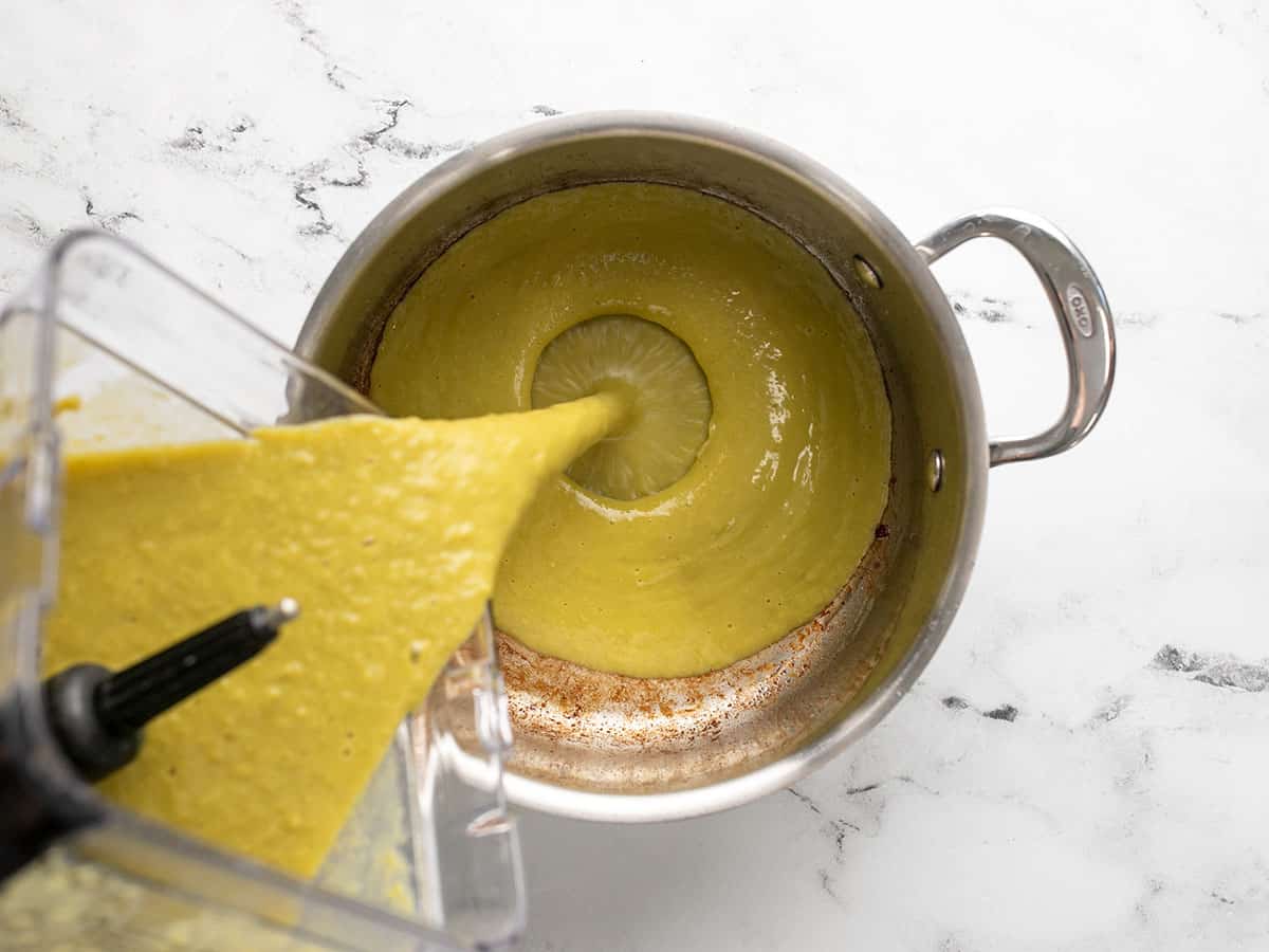 Pea soup being poured from the blender into the pot.