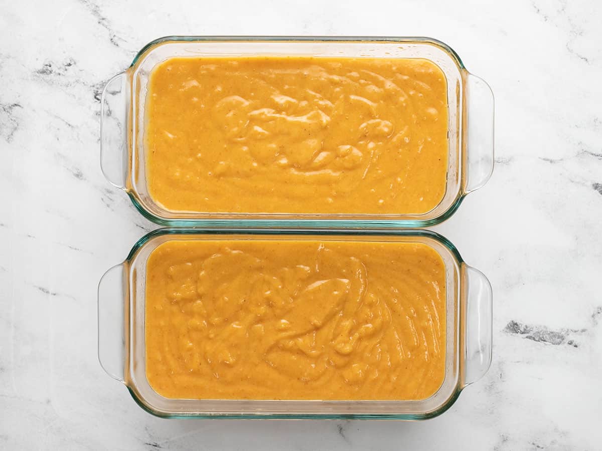 Overhead shot of two loaf pans of pumpkin bread. batter.