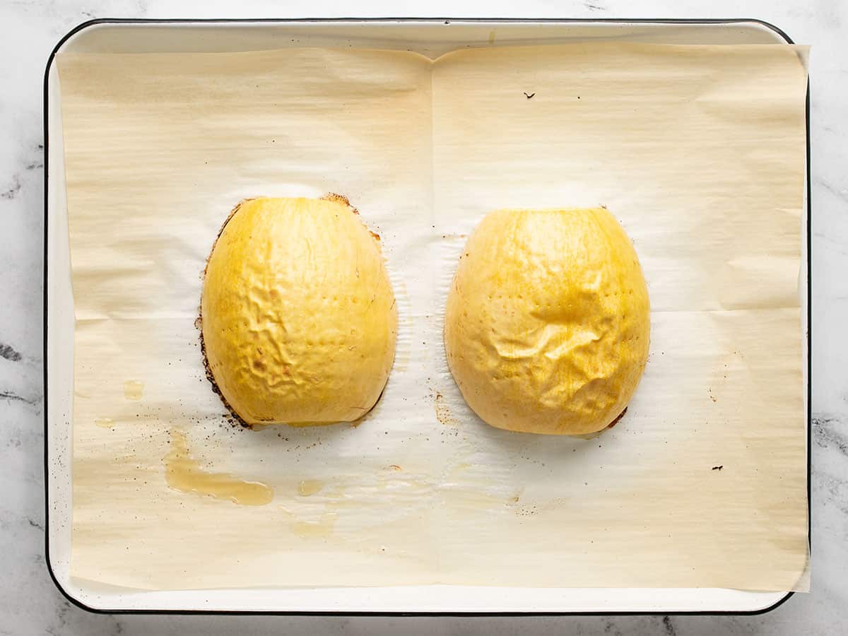 Overhead shot of roasted spaghetti squash cut side down on a sheet pan.