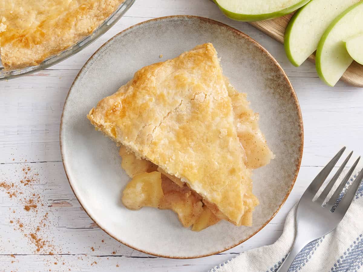 Overhead view of a slice of apple pie on a plate.