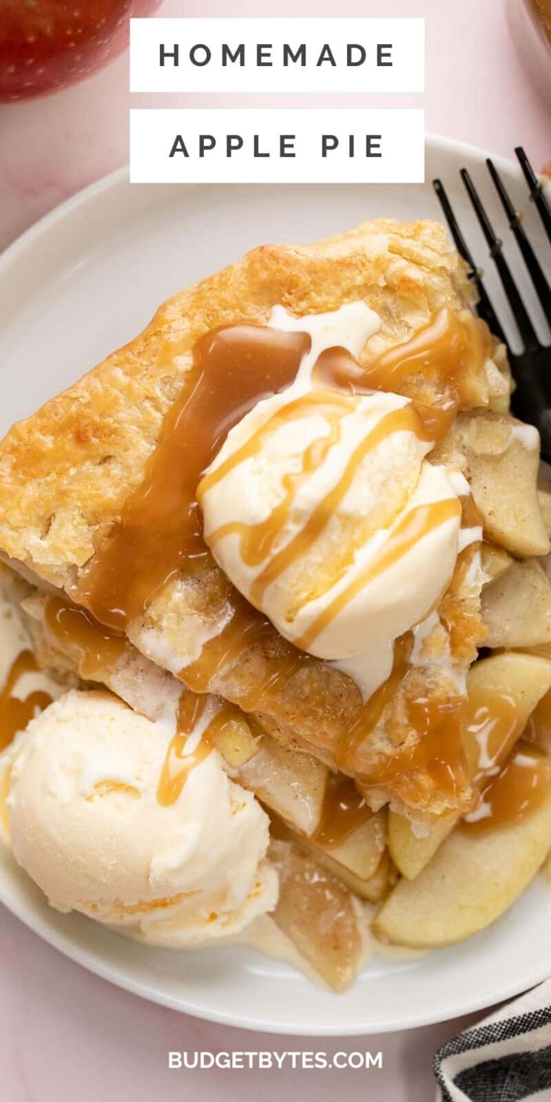 Overhead shot of a slice of apple pie on a white plate with two scoops of vanilla ice cream and drizzled with caramel sauce.