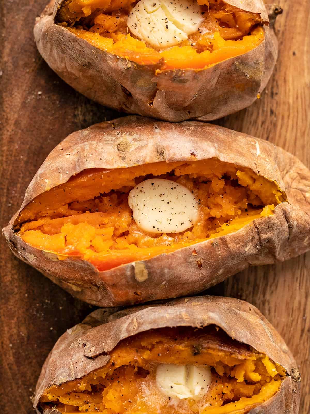 Close up overhead shot of baked sweet potatoes with butter.