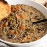 Close up side view of a bowl of creamy lentil vegetable soup.