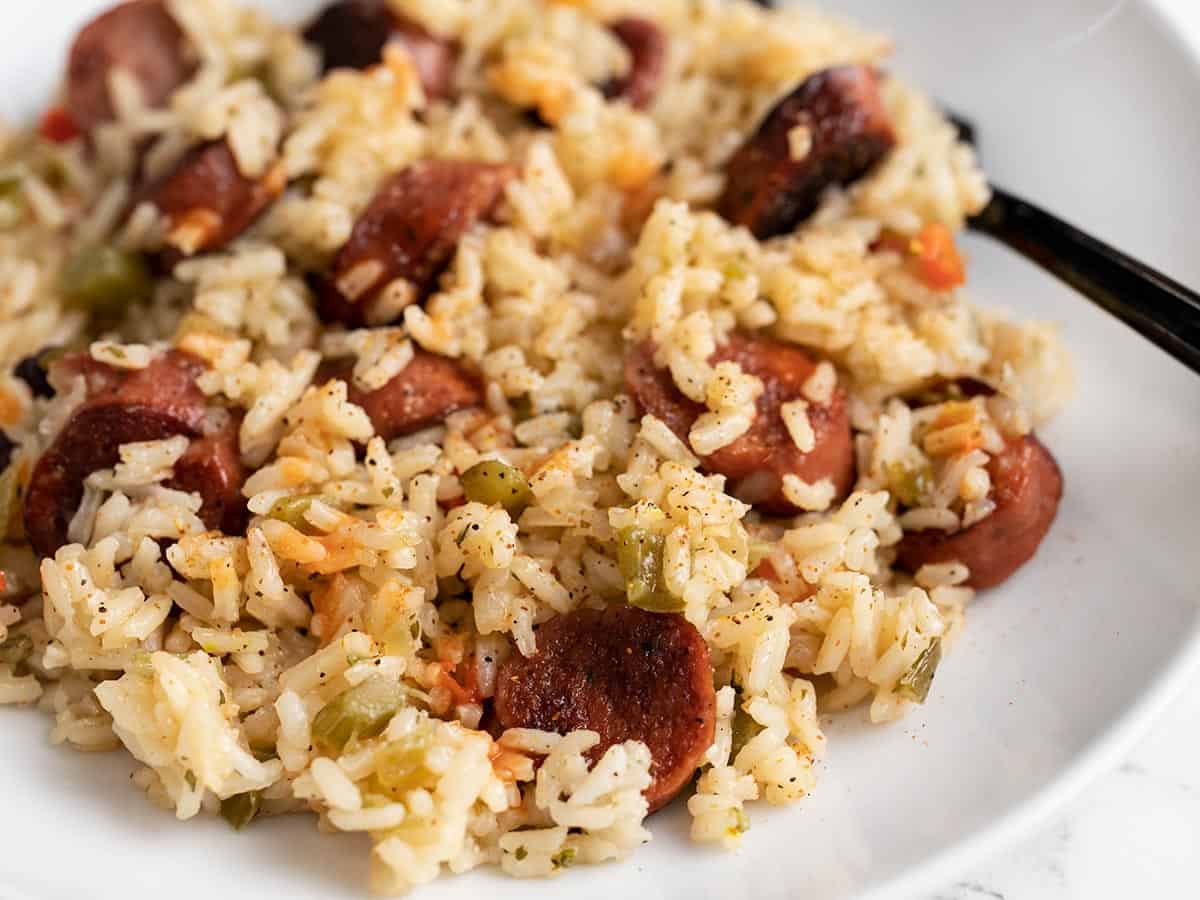 close up side view of a plate full of sausage and rice.