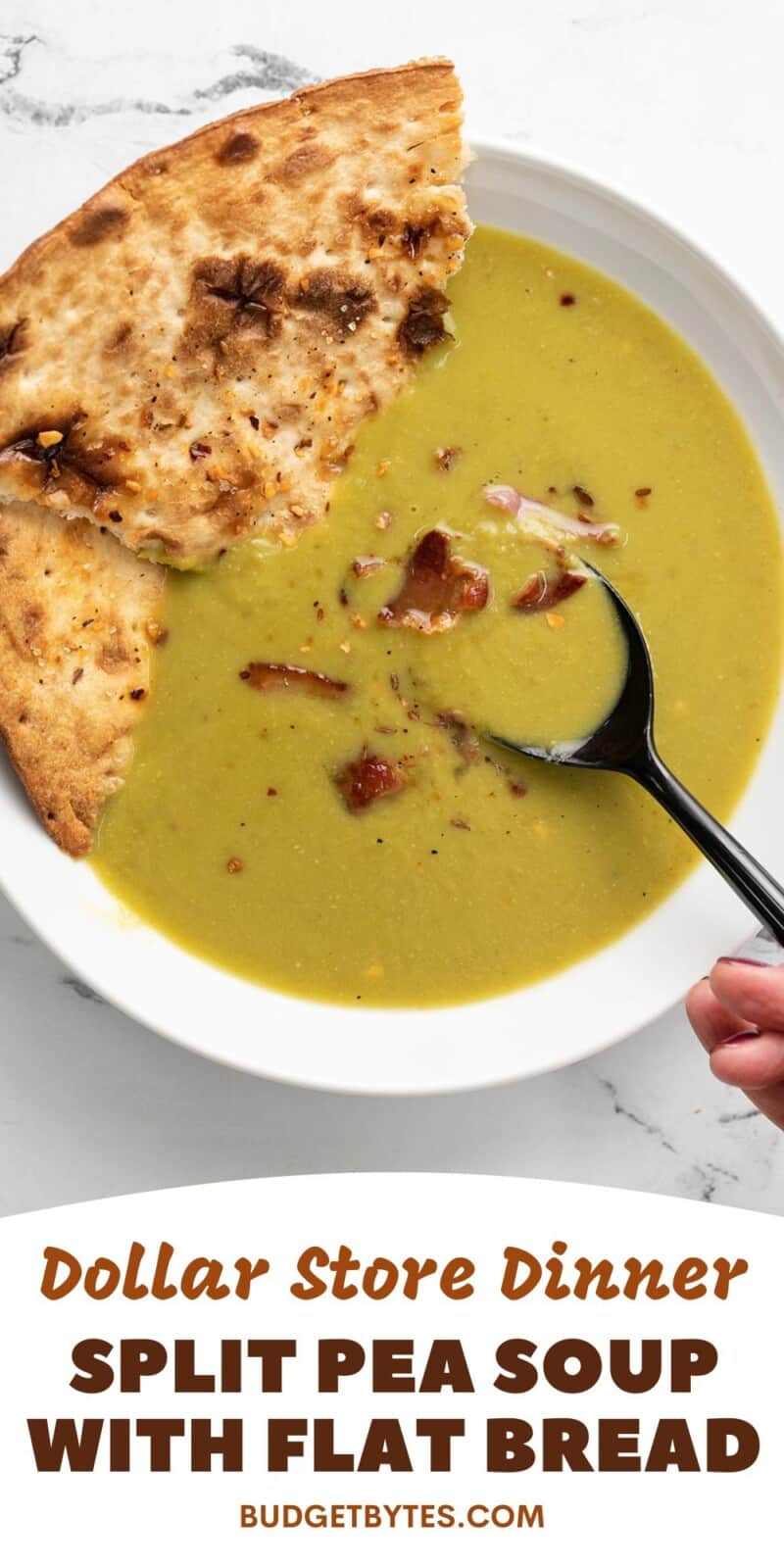 Overhead view of pea soup with a spoon in the middle and flatbread on the side.