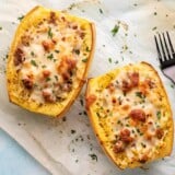 Overhead shot of stuffed spaghetti squash with a black fork next to it.