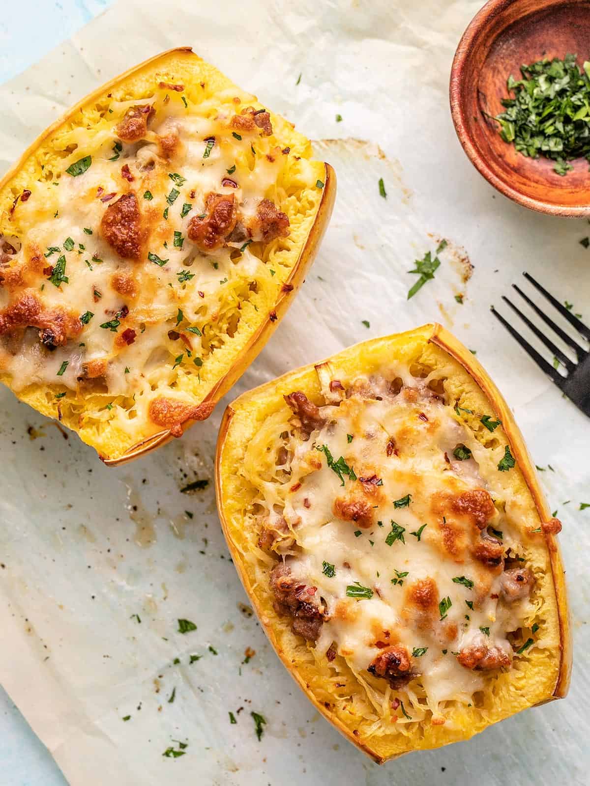 Overhead shot of stuffed spaghetti squash with a black fork next to it