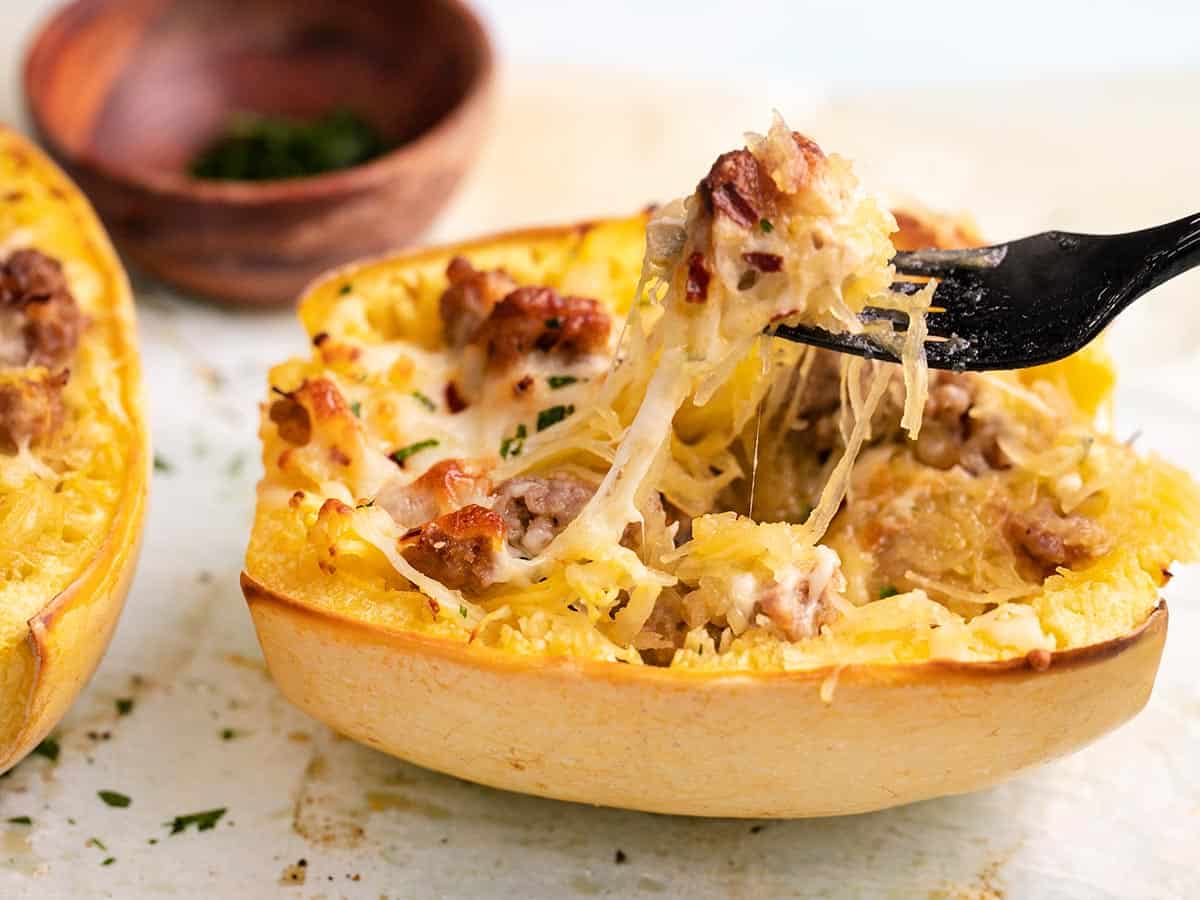 Side shot of Sausage Stuffed Spaghetti Squash with a fork in it.