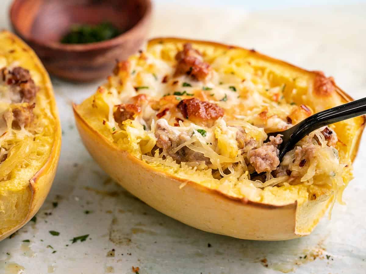 Side shot of Sausage Stuffed Spaghetti Squash with a fork in it.