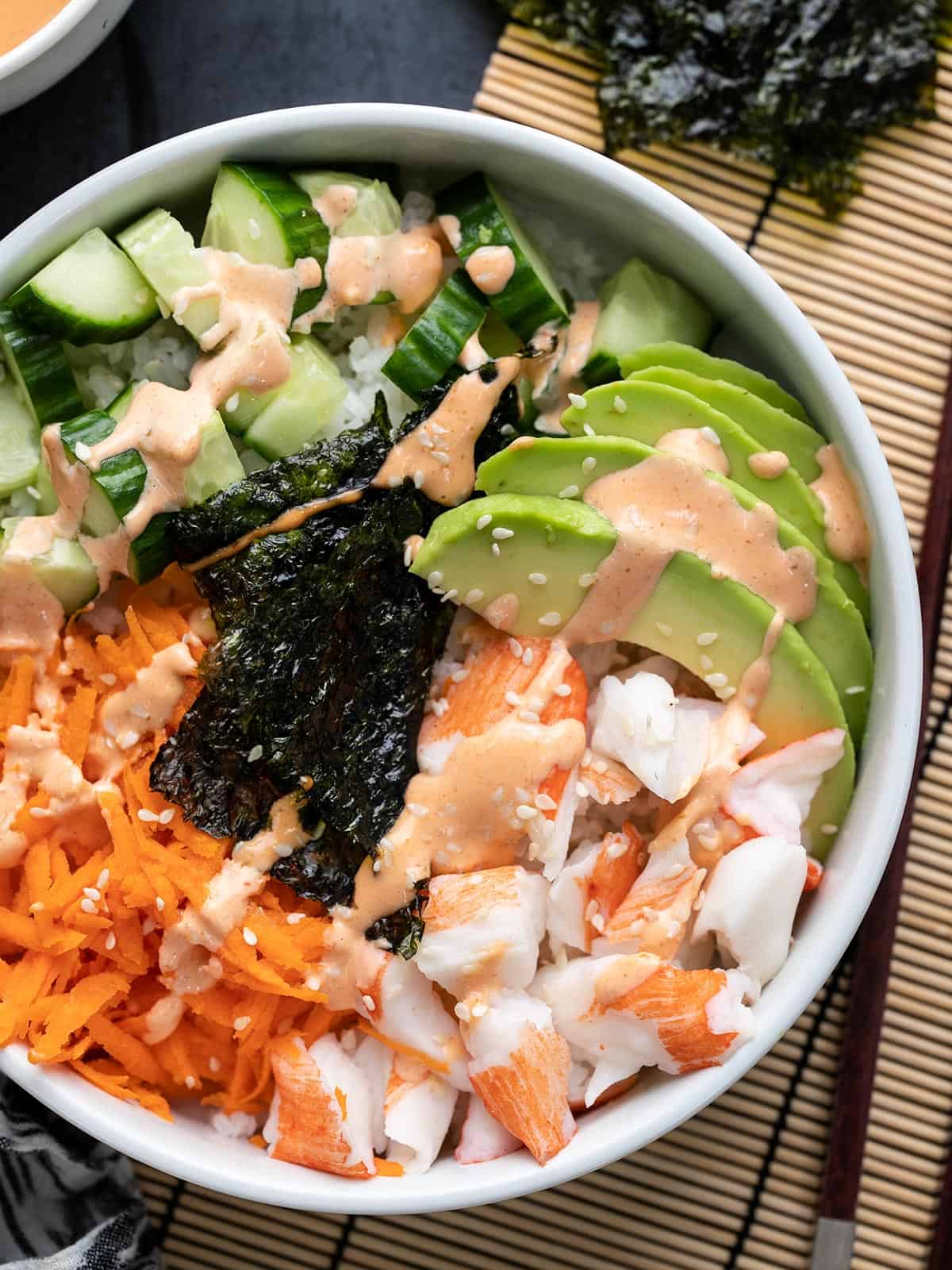 Close up overhead view of a sushi bowl with sriracha mayo.