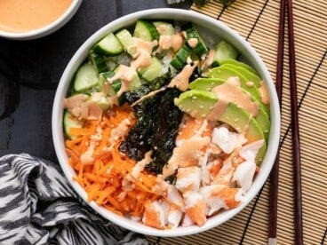 Completed sushi bowl from above on a dark background.