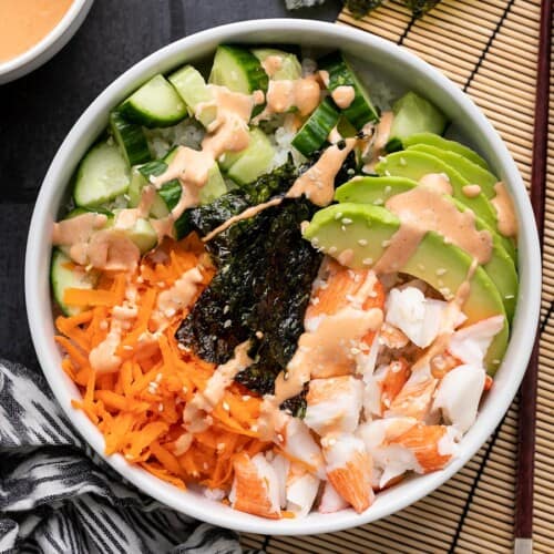 Completed sushi bowl from above on a dark background.