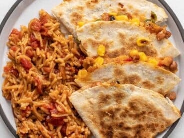 Overhead view of bean quesadillas on a plate with Spanish RIce.