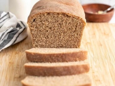 Front view of a loaf of honey wheat bread sliced.