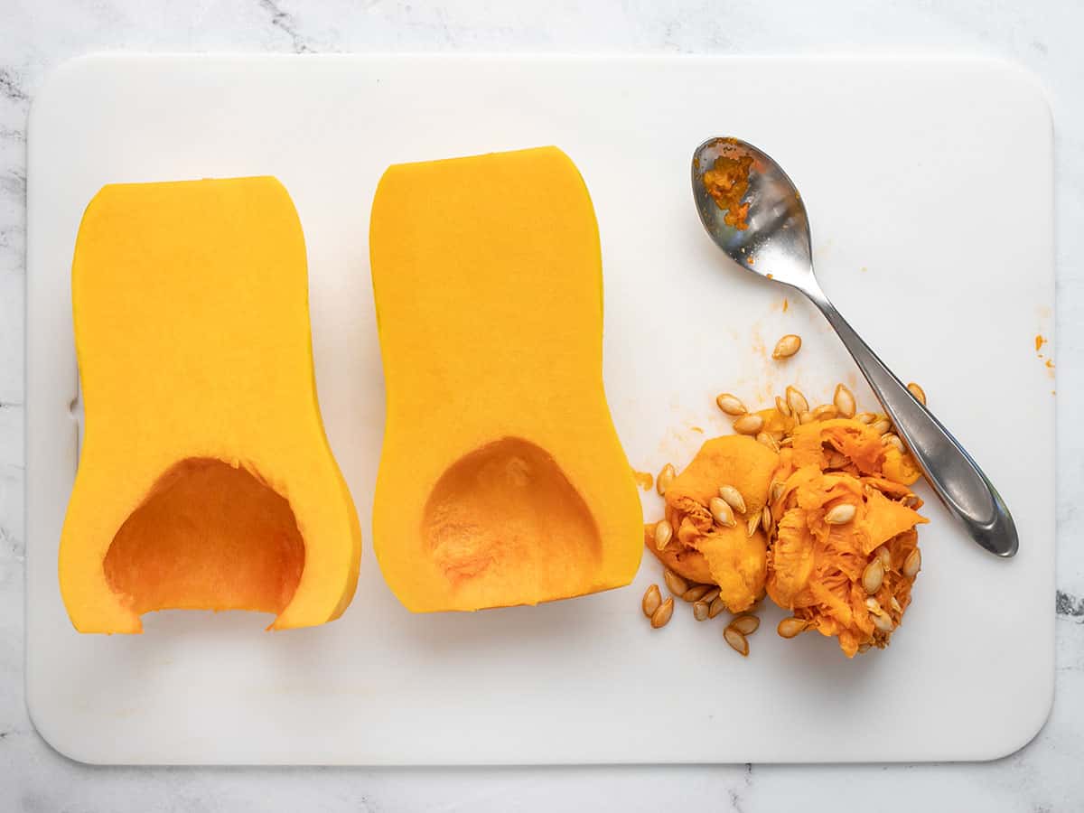 Seeds scooped out of butternut squash with a spoon.