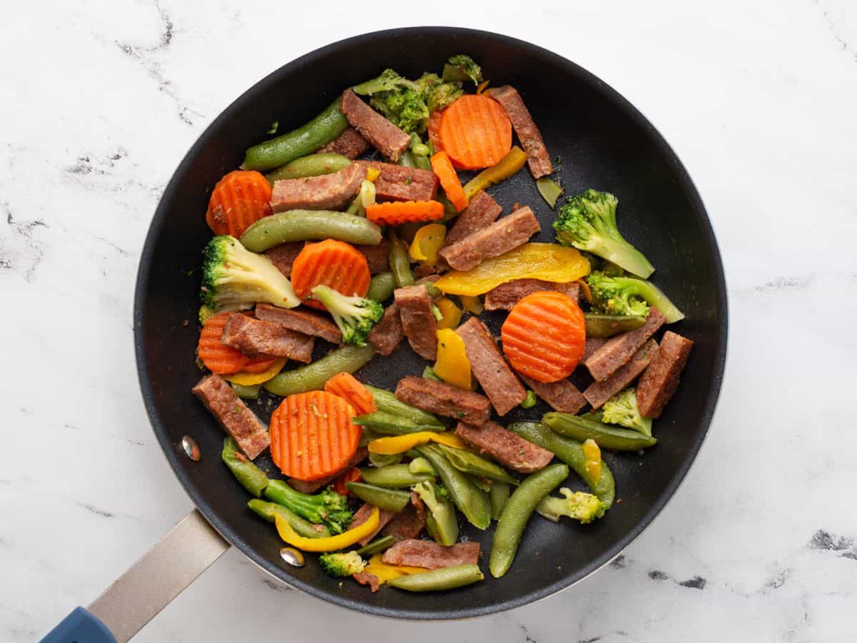 Frozen vegetables added to the skillet.