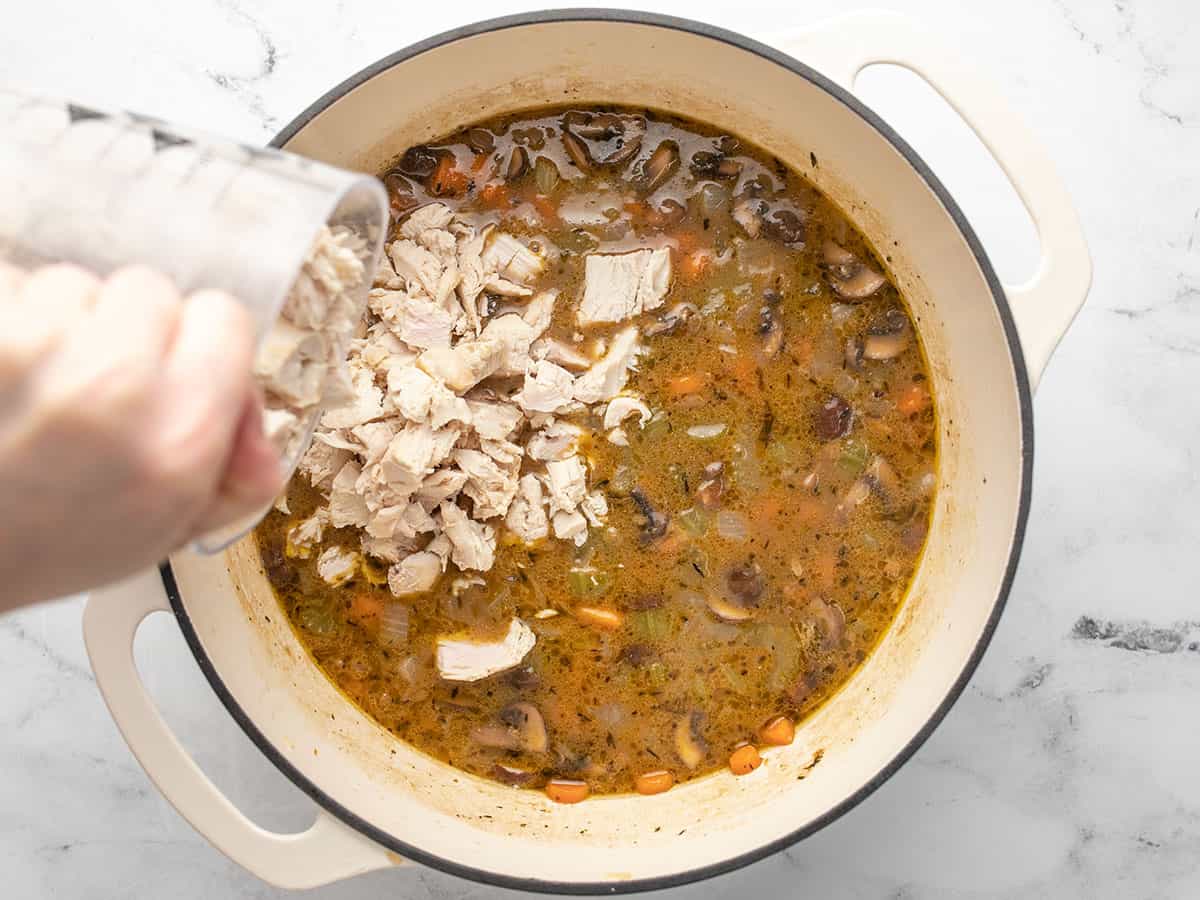 Chopped turkey being poured into the pot.