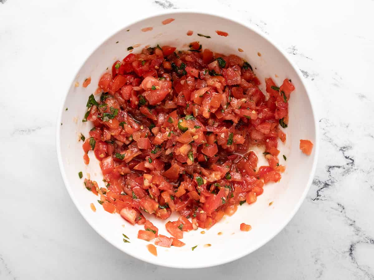 Overhead shot of a white bowl with tomato mixture.
