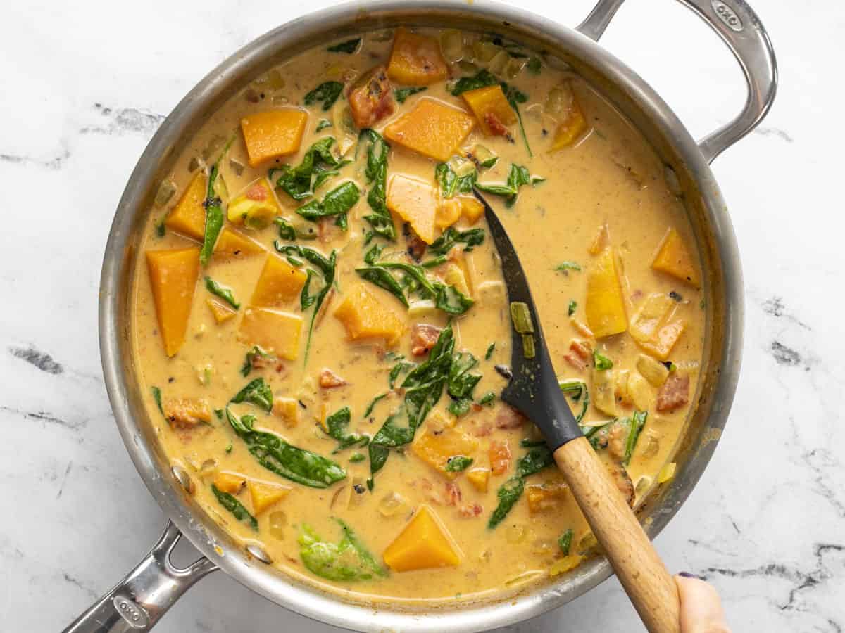 Finished curry in the skillet with a spatula.