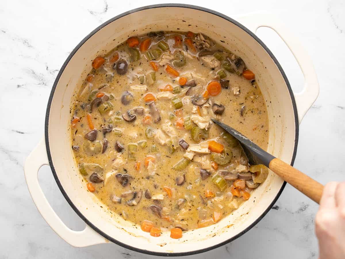 Finished soup in the pot with a spoon.