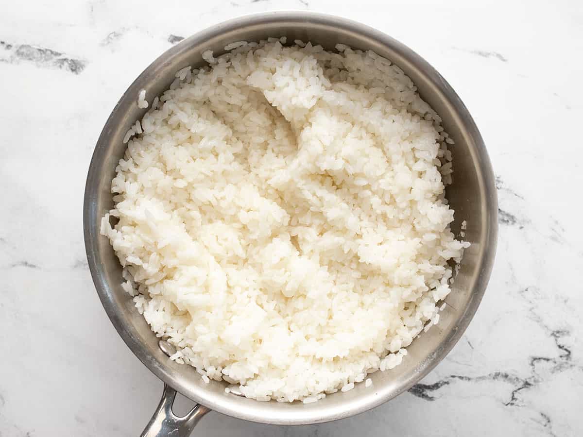 Overhead shot of cooked rice in a silver pot.