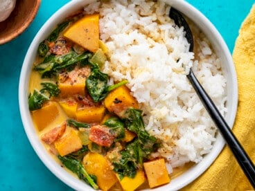 Close up overhead view of butternut squash curry in a bowl with rice.