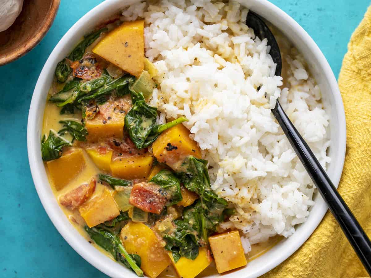 Close up overhead view of butternut squash curry in a bowl with rice.