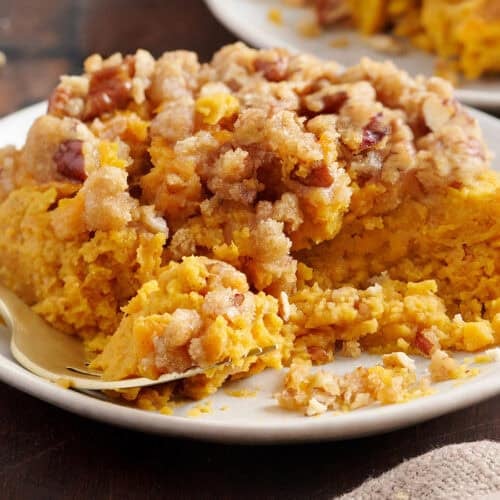 Sweet potato casserole on a plate with a fork.