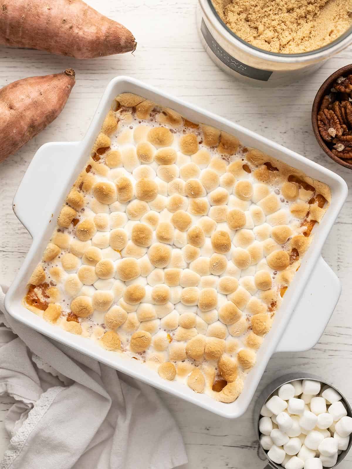 Overhead shot of sweet potato casserole topped with marshmallows in a white casserole dish.