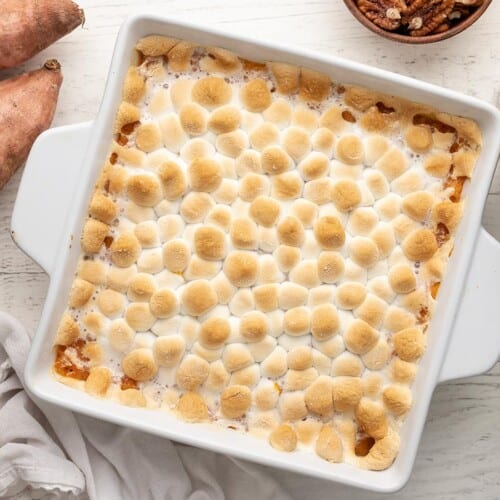 Overhead shot of sweet potato casserole topped with marshmallows in a white casserole dish.