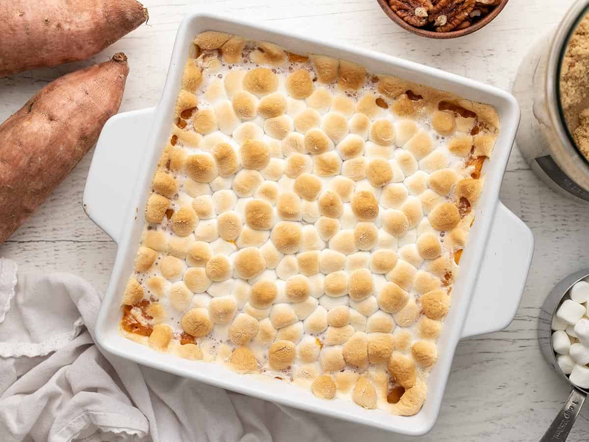 Overhead shot of sweet potato casserole topped with marshmallows in a white casserole dish.