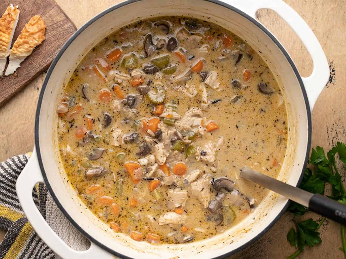 Overhead view of turkey and wild rice soup in the pot with a ladle.