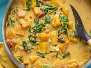 Overhead view of a skillet full of butternut squash curry.