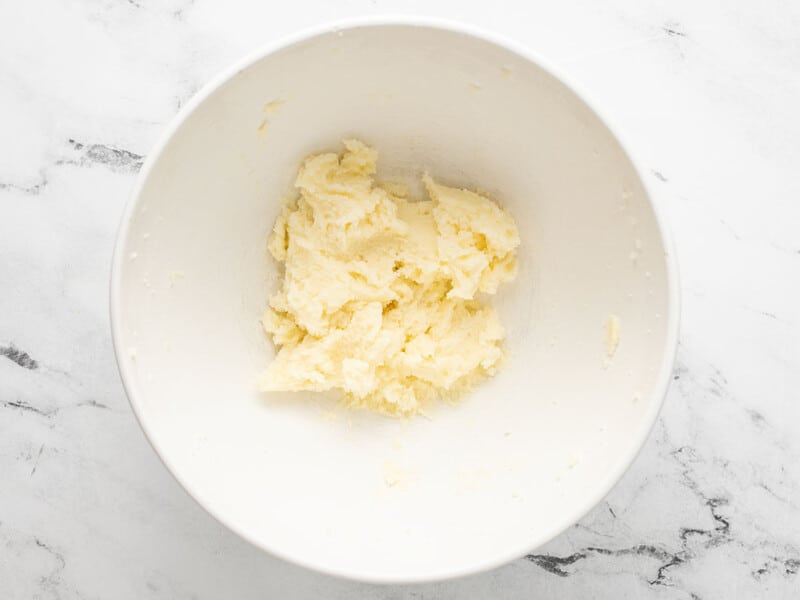 Overhead shot of creamed butter and sugar in a white bowl.