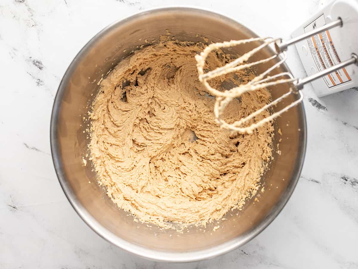 Creamed butter and sugar in a bowl with a hand mixer on the side. 